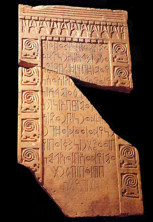 Iscrizione minea (as-Sawdā’ 88), incisa su stele decorata con fregio in rilievo a motivi geometrici (dentelli, scanalature) e figurativi (protomi di toro, stambecchi accucciati), proveniente da Nashshān/as-Sawdā’ (VII sec. a. C.).